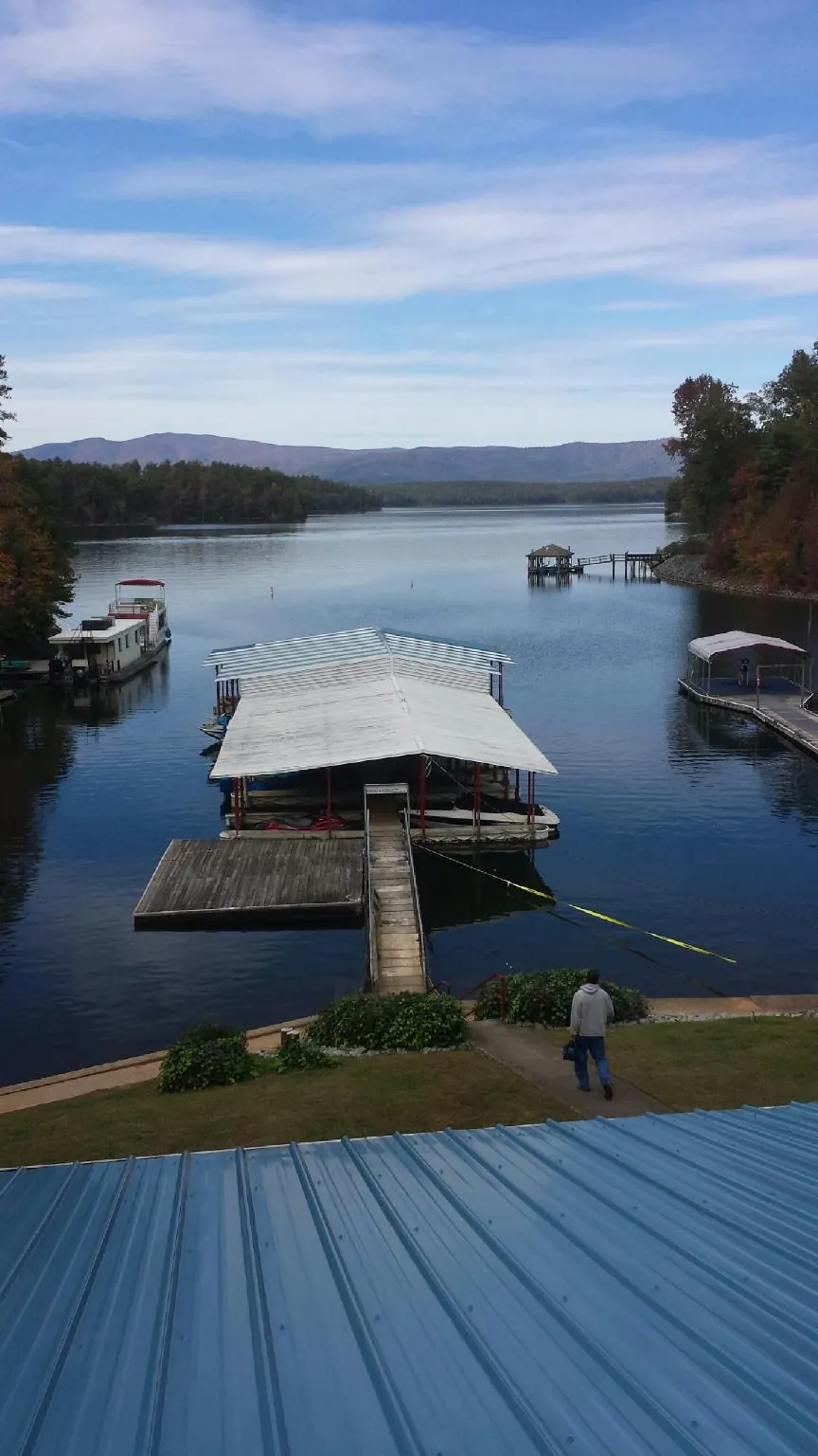 View across a lake from a newly installed blue metal roof in Palmetto